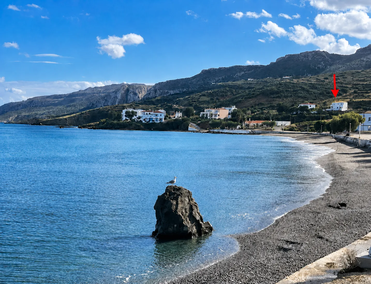 Pebble beach with coastal hills near Agia Pelagia